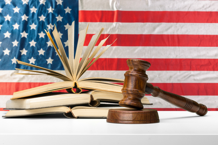 legal concepts represented by a gavel on books in front of the american flag backdrop