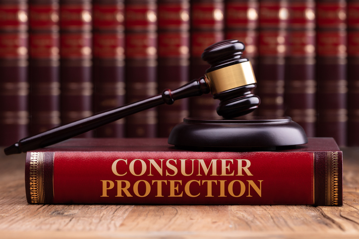 wooden gavel and soundboard on consumer protection law book