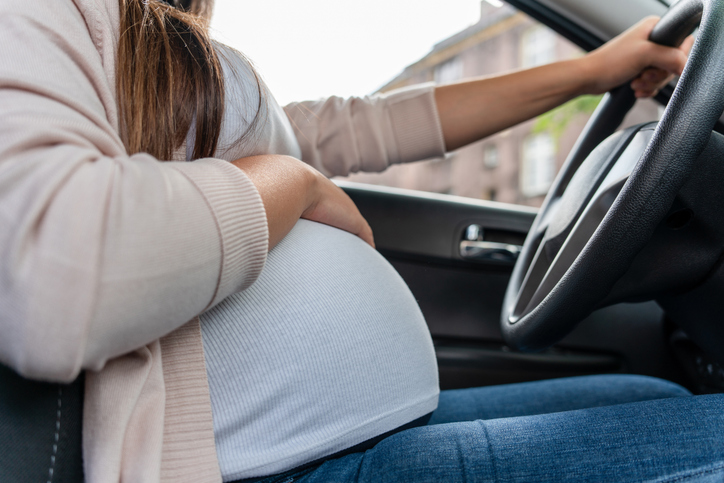 woman driving car. beautiful smiling pregnant woman driving car. safety pregnancy young mother drive concept.